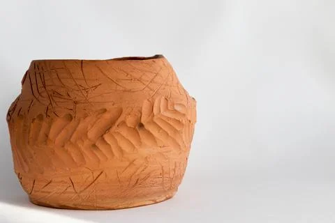 Handmade clay pot with a pattern on a white background. Copy space Stock Photos