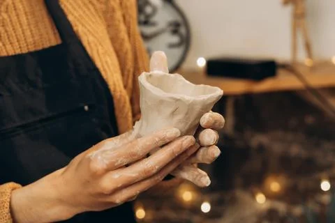 Handmade clay pot in pottery studio with blurred lights background. Creative  Stock Photos