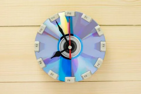 Handmade clock from a dvd disk and keyboard on a wooden wall Stock Photos