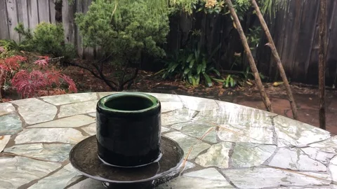 Handmade cup in the rain on a stone table Stock Footage 99017919