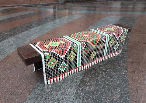 Handmade decorative bench in the form of a lying ornamental towel made of mosaic Foto stock