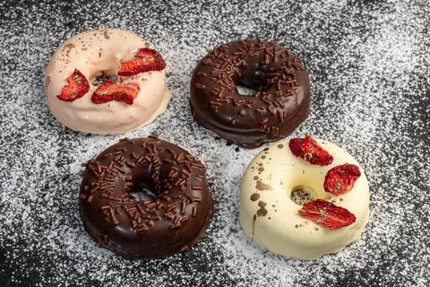 Handmade donuts on a light background in white and black chocolate. There are Фото