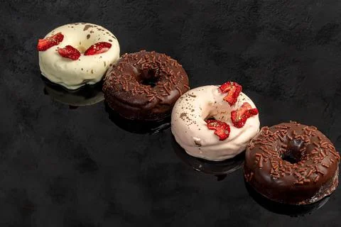 Handmade donuts on a light background in white and black chocolate. There are Фото