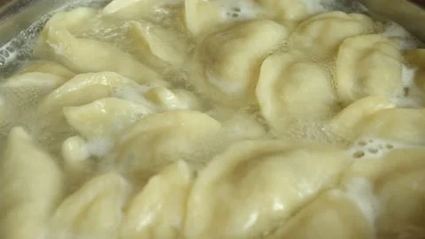 Handmade dumplings are boiled in boiling boiling water in a saucepan Stock Footage 231340186