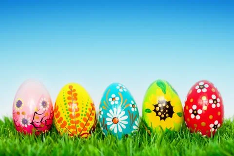 Handmade Easter eggs on grass. Spring patterns, unique. Stock Photos