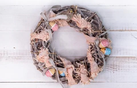 Handmade Easter wreath made of twigs and ribbons with cute bird and wooden eggs. Fotos de archivo