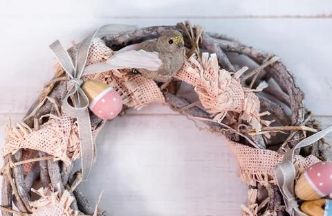 Handmade Easter wreath made of twigs and ribbons with cute bird and wooden eggs. Fotos Stock