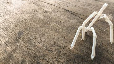 Handmade eco figure using bendy straws and cardboard torso on aged wooden t.. Stock Photos
