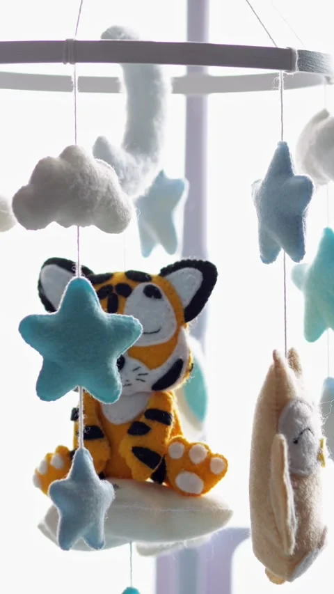 Handmade felt baby mobile with sleeping tiger, owl, and stars gently rotating Stock-Footage 341284553