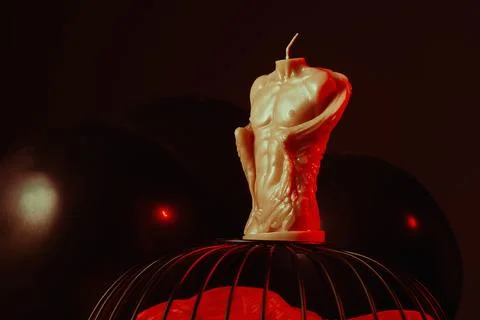 Handmade figural sich in the shape of a man's torso in red on a dark background Stock Photos