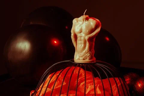 Handmade figural sich in the shape of a man's torso in red on a dark background Stock Photos