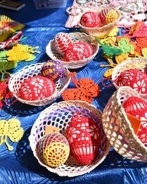 Handmade folk crochet easter eggs in baskets colorful traditional spring craft Stock Photos
