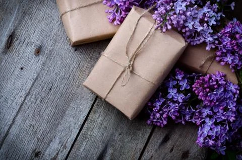 Handmade gift boxes wrapped with craft brown paper, decorated with fresh purp Stock Photos