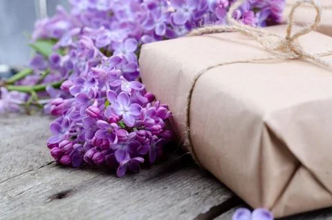 Handmade gift boxes wrapped with craft brown paper, decorated with fresh purp Stock Photos