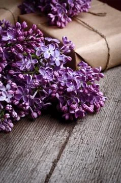 Handmade gift boxes wrapped with craft brown paper, decorated with fresh purp Stock Photos