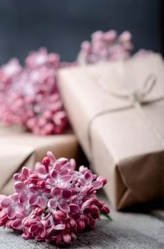 Handmade gift boxes wrapped with craft brown paper, decorated with fresh purp Stock Photos