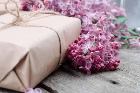 Handmade gift boxes wrapped with craft brown paper, decorated with fresh purp Stock Photos