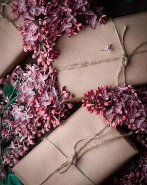 Handmade gift boxes wrapped with craft brown paper, decorated with fresh purp Stock Photos