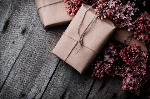 Handmade gift boxes wrapped with craft brown paper, decorated with fresh purp Stock Photos