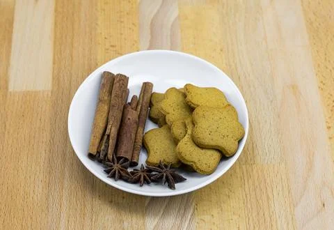 Handmade ginger biscuit of flower form with cloves and anise on a white plate Stock Photos