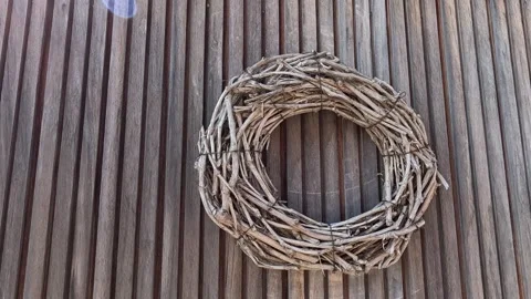 A handmade grapevine wreath hangs on the wall, serving as a decorative home.. Stock Footage 339629852