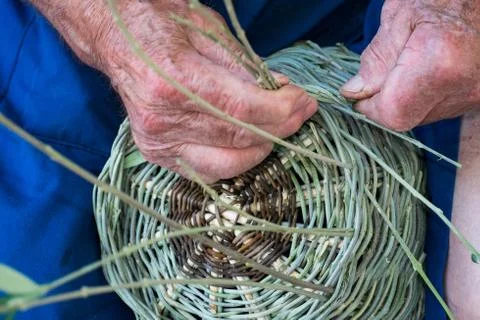 Handmade hands while making a wicker basket Stock Photos