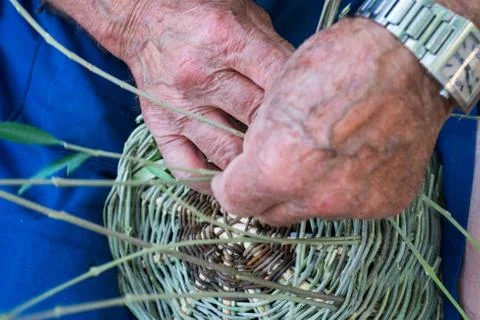 Handmade hands while making a wicker basket Stock Photos