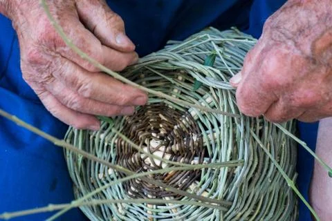 Handmade hands while making a wicker basket Stock Photos
