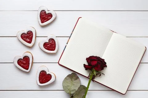 Handmade heart shaped cookies with empty notebook and rose flower on white Stock Photos