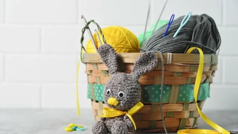 Handmade knitted toy Easter rabbit, and knitting accessories in the basket Stock Footage 149326419