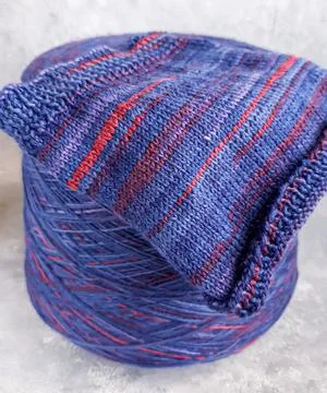 Handmade knitting pattern. Knitted fabric from a multi-colored thread and a.. Фото