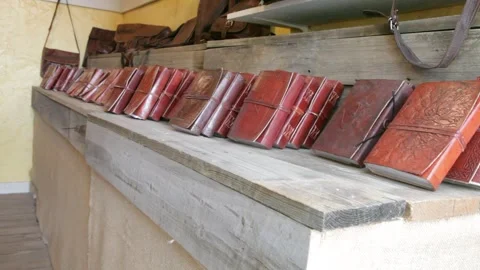 Handmade Leather Bound Journals Displayed on Wooden Shelf Stock Footage 345279137