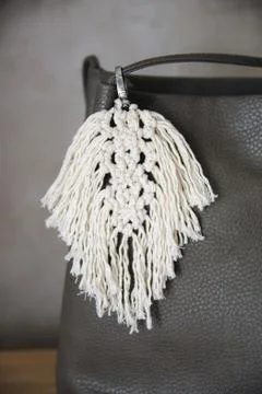 Handmade macrame keychains are made of natural cotton thread and attached to Stock Photos