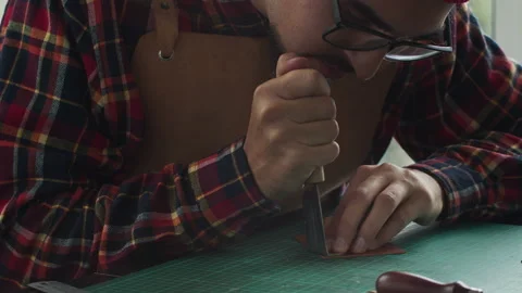 Handmade man hobbies. Young leather craftsman creates bag product for e-commerce Stock Footage 141605904
