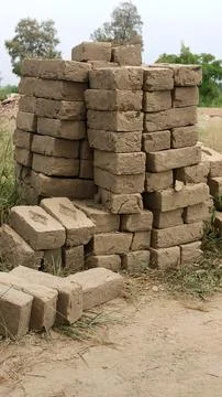 Handmade Mud Bricks Stacked in Pile Outdoors on Rural Ground Dirt Stock Photos