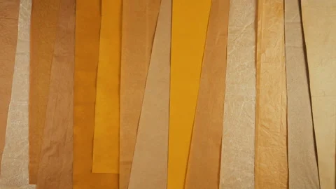 Handmade natural paper background in warm yellow, orange, and brown tones. Video stock 329712997