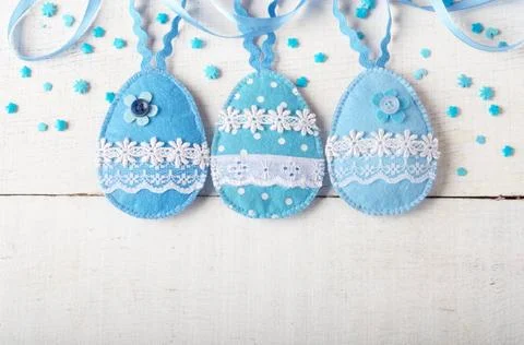 Handmade patchwork blue felt easter eggs on white wooden table Handmade pa... Stock Photos
