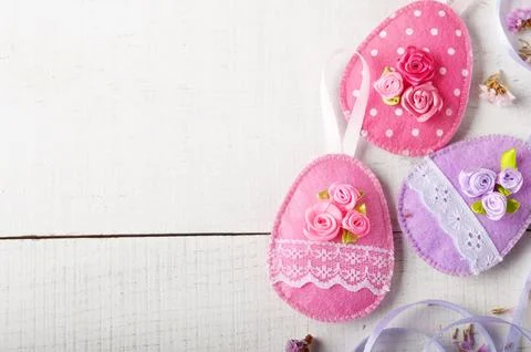 Handmade patchwork blue felt easter eggs on white wooden table Stock Photos