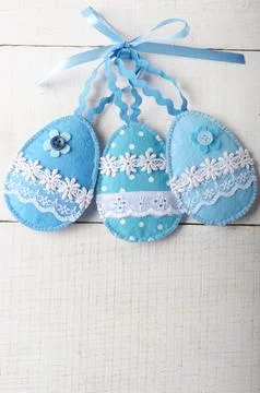 Handmade patchwork blue felt sewed easter eggs on white wooden table 스톡 사진
