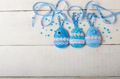 Handmade patchwork blue felt sewed easter eggs on white wooden table Foto stock