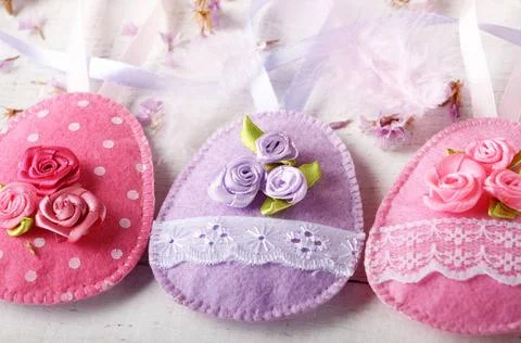 Handmade patchwork pink and lilac felt easter eggs on white wooden table H... Stock-Fotos