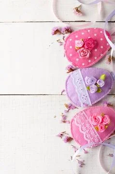 Handmade patchwork pink felt easter eggs on white wooden table Fotos de archivo