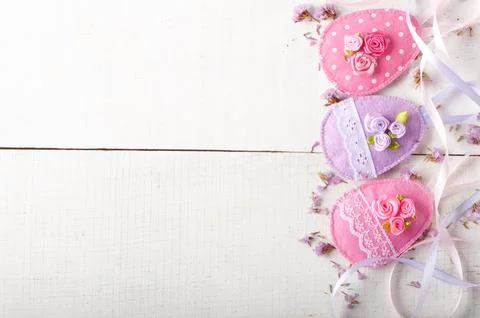 Handmade patchwork pink felt easter eggs on white wooden table Stock-Fotos