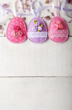 Handmade patchwork pink felt easter eggs on white wooden table Stock-Fotos