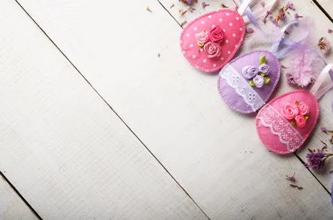 Handmade patchwork pink felt easter eggs on white wooden table Stock-Fotos