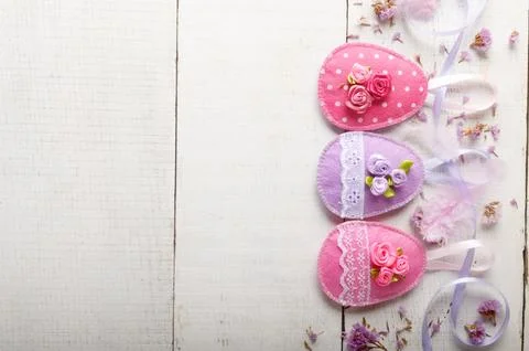Handmade patchwork pink felt easter eggs on white wooden table 스톡 사진