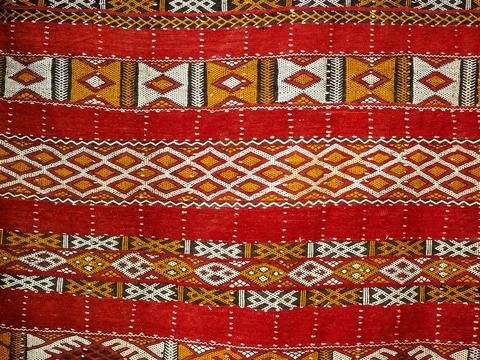 Handmade pattern decorated cloth or textile rug on display at street market in Foto stock