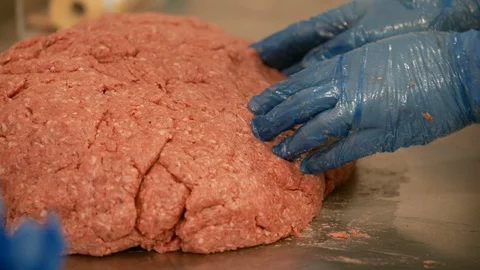 Handmade raw beef mince burger shaping using blue food preparation gloves Video stock 125588583