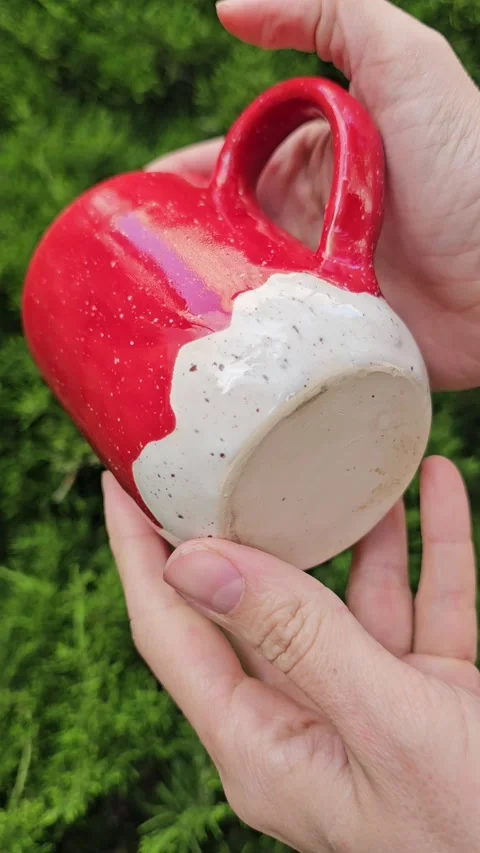 Handmade Red Ceramic Mug with Handle – Slow Rotation Close-Up in Female Hands Video stock 321370114