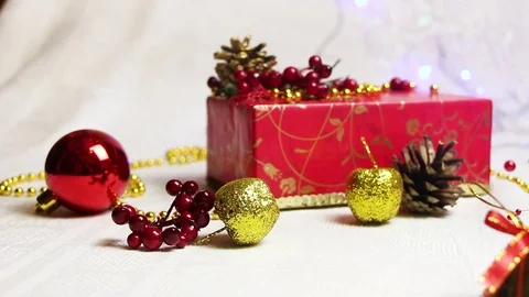 Handmade red gift box and Christmas decorations, golden apples and bumps with Video stock 82407673